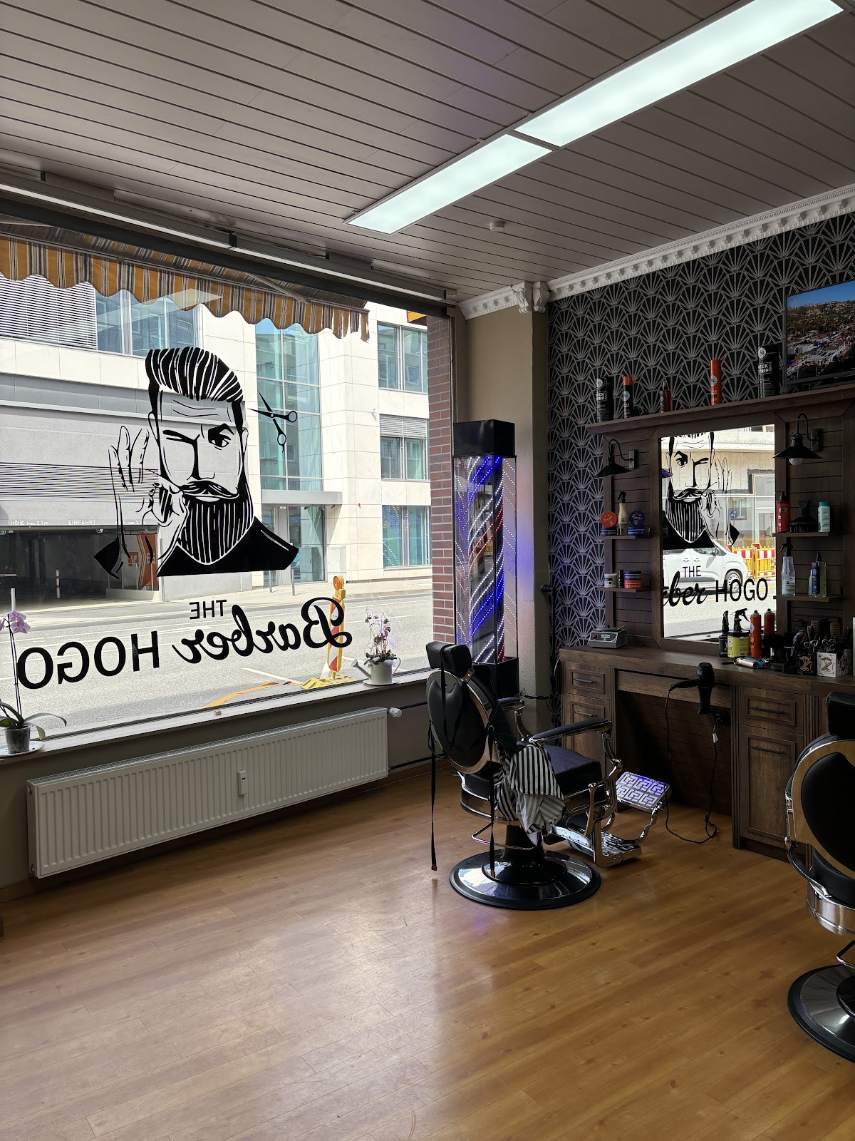 The Barber Hogo — Blick in den Laden mit goldenem Schaufenster-Logo